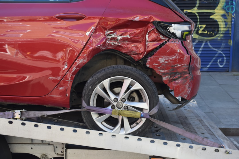 a red car is on a flatbed tow truck — Foto por Usman Malik na Unsplash